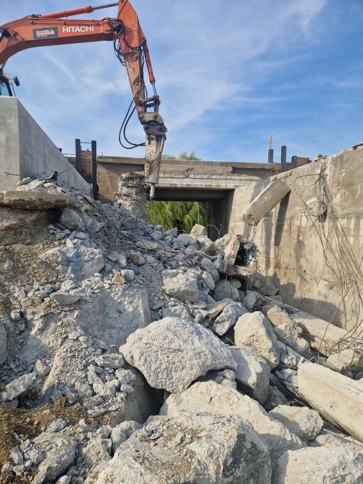 Excavator spargand beton armat pe santier