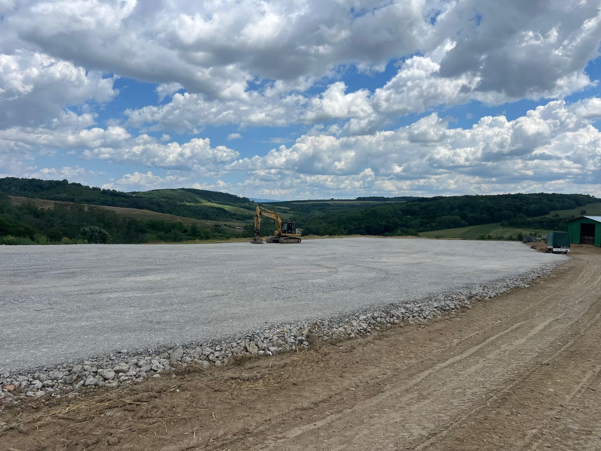 Platforma din beton concasat finalizata, cu excavator in fundal